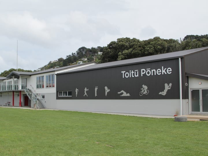 Large sports centre building with Toitu Poneke signage and sports silhouettes