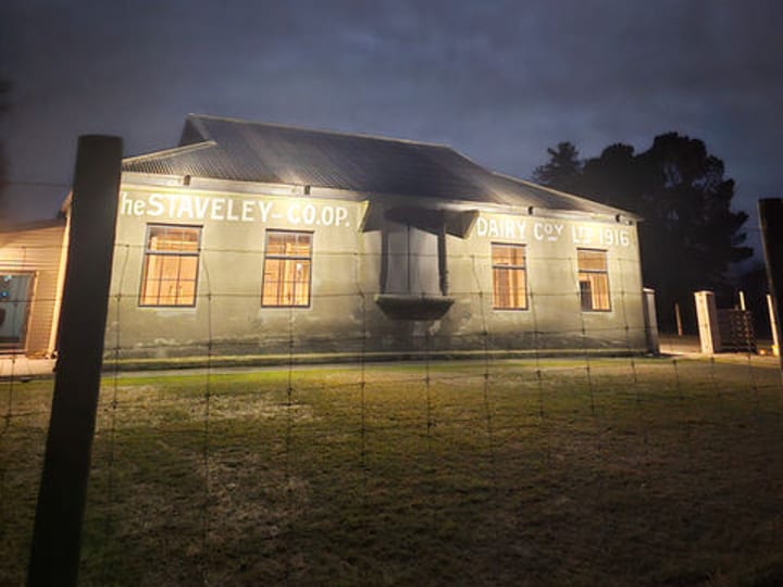 Historic corrugated iron building at night with moon and painted signage
