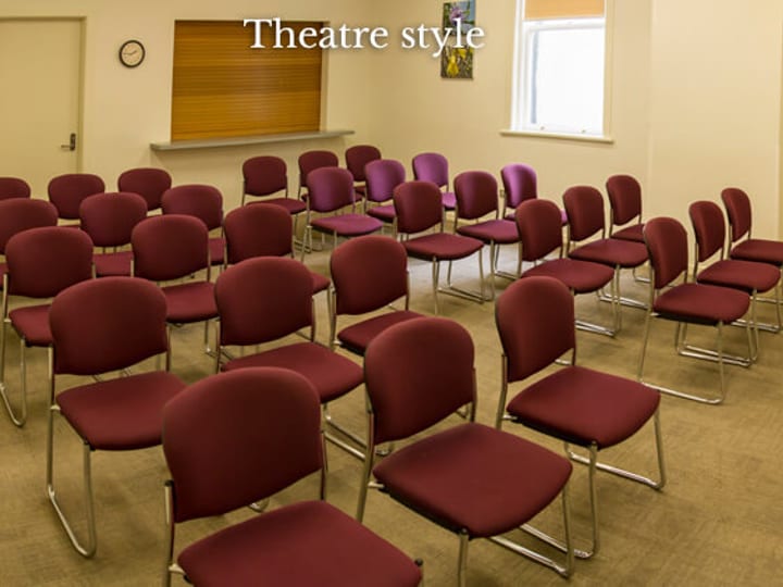 Small meeting room with chairs in theatre-style layout and whiteboard