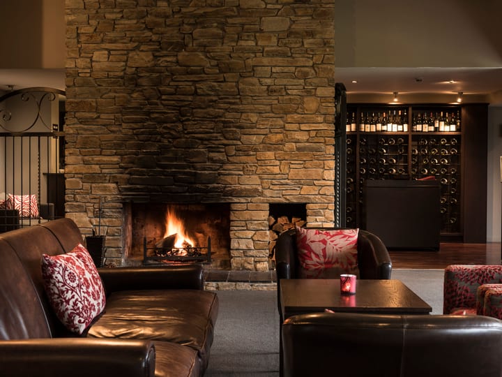 Dark lounge interior with leather sofa, textured wallpaper and framed oil painting