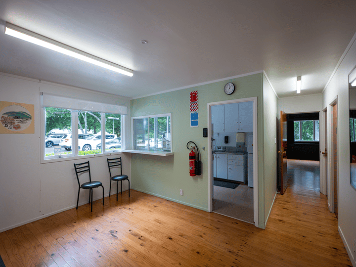 Light-filled foyer with timber floor and servery hatch to kitchen