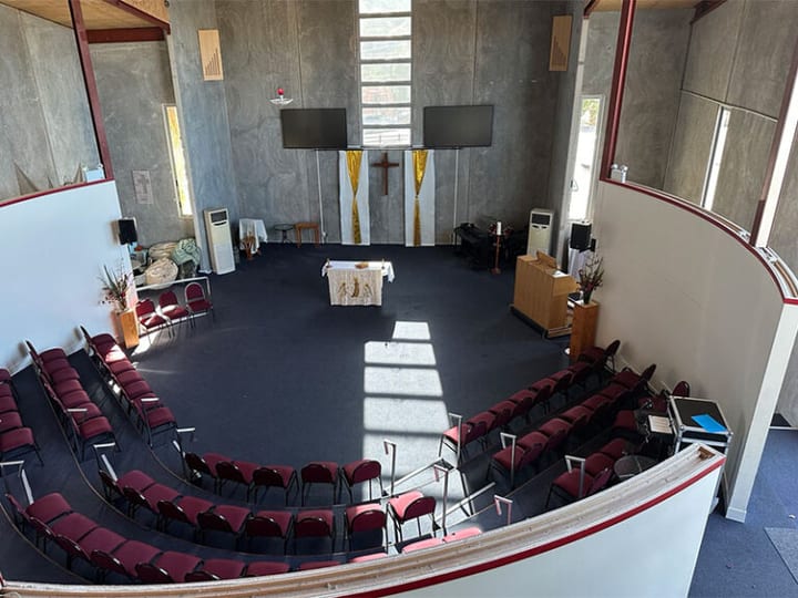 Church interior side wall showing large timber cross and concrete walls