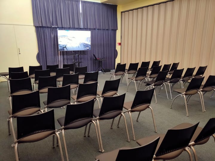 Small meeting room with chairs in rows and projector screen
