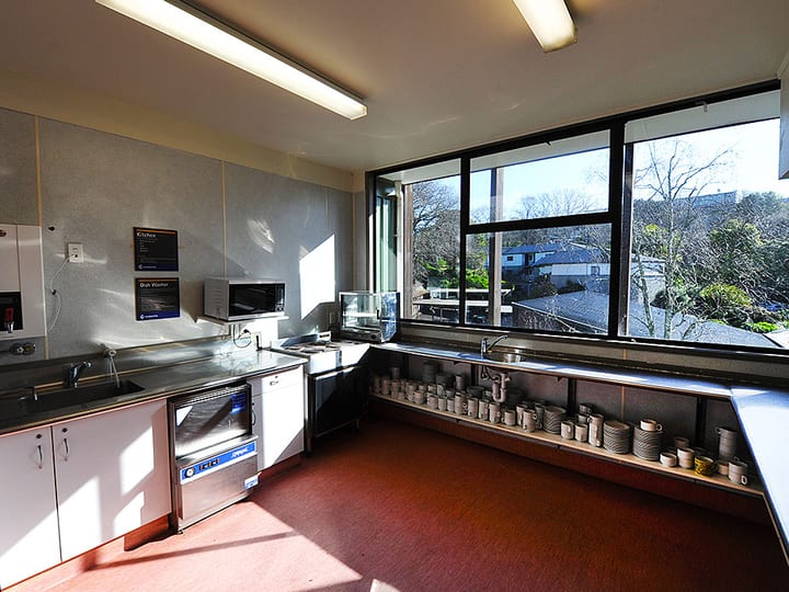Commercial kitchen with stainless bench, window view over rooftops