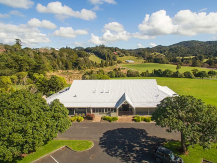 Aerial view of a large white-roofed event centre building set in rural farmland