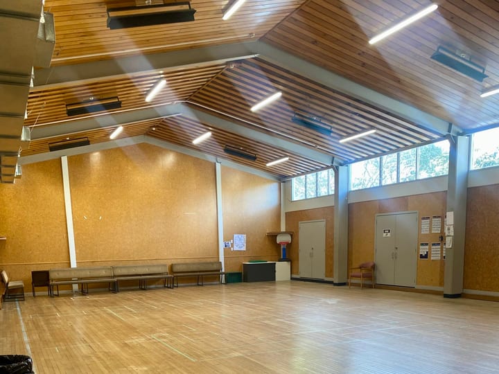 Large hall with timber ceiling, wooden floor, and high clerestory windows