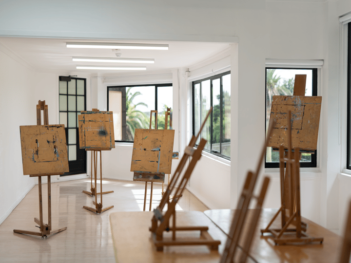 Art studio with wooden easels and canvases, natural light through corner windows