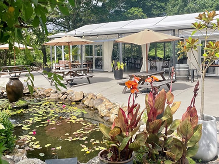 Pond with garden plantings and a marquee structure in the background