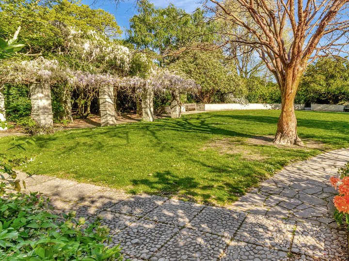 Formal garden with stone pergola, lawn, and flowering plants