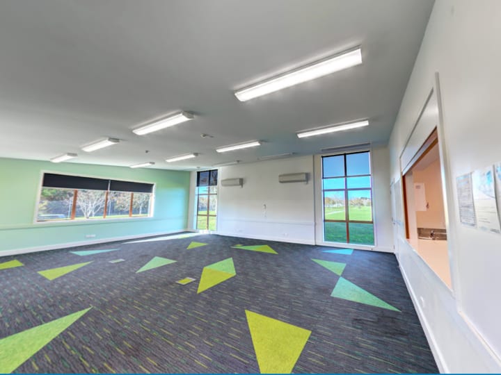 Empty function room with patterned carpet tiles and large windows