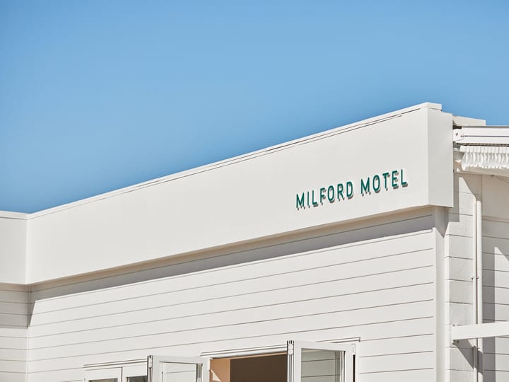 White motel building facade with signage under blue sky