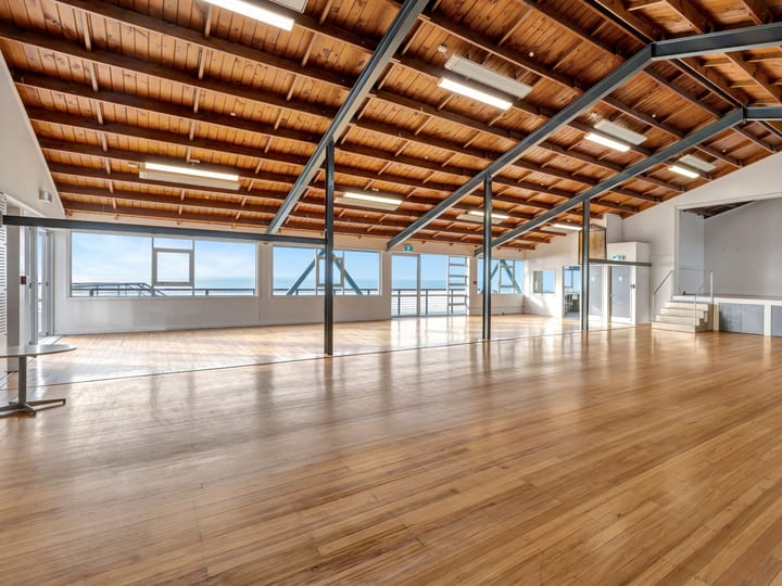Large open hall with timber ceiling, exposed steel beams and polished wood floors