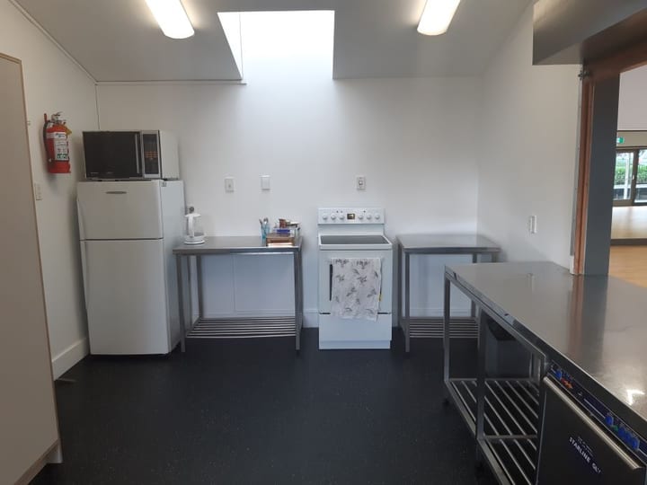 Plain kitchen with stainless steel benches, fridge and appliances
