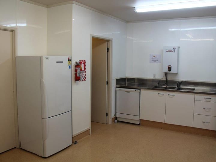 Small kitchen with fridge, dishwasher and stainless sink bench