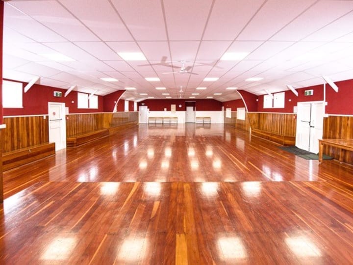 Large empty hall with polished red-brown timber floor, red painted walls, timber wainscoting