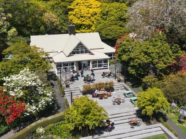 Aerial view of venue building and deck surrounded by mature garden trees