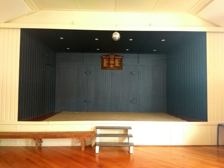 Raised platform area with blue painted back wall and disco ball above