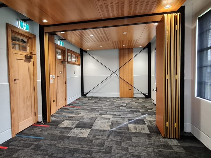 Corridor with timber ceiling, timber partition doors, and tiled carpet