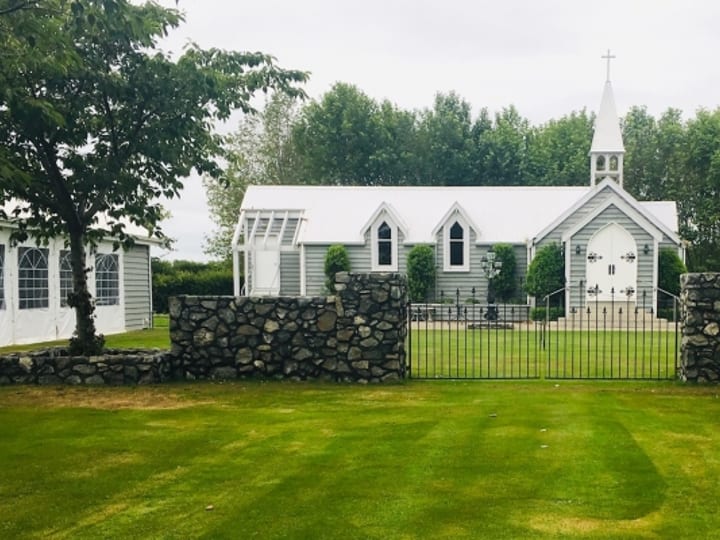 Chapel and garden with iron gates, stone walls and lawn