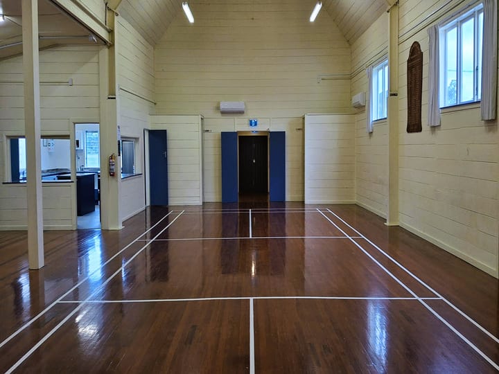 Hall interior with polished floor and stacked chairs along one wall