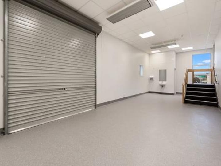 Room with roller door, resin floor and staircase
