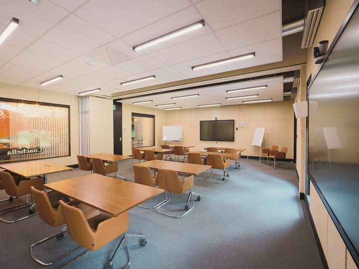 Training room with rows of tables and chairs, interactive screens, and a whiteboard