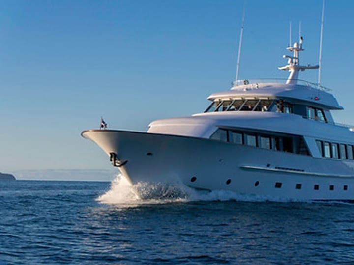 Motor yacht underway in calm blue water, bow-on view