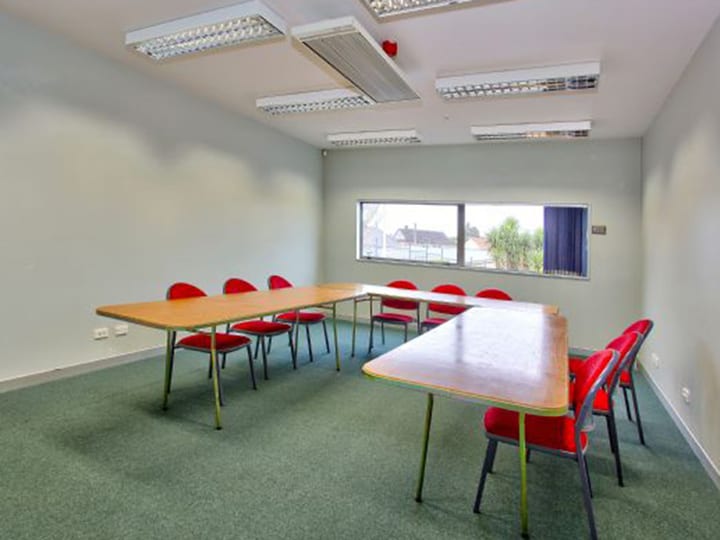 Meeting room with u-shaped table arrangement and red chairs