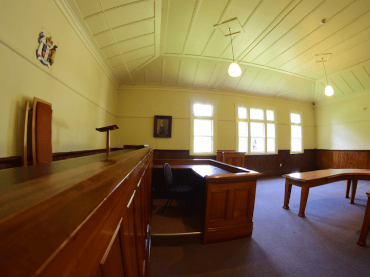 Timber-panelled heritage room with pitched ceiling, bench seating, and tall windows