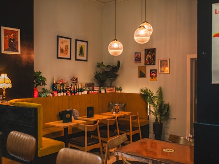 Intimate dining nook with warm pendant lights, booth seating and framed artwork