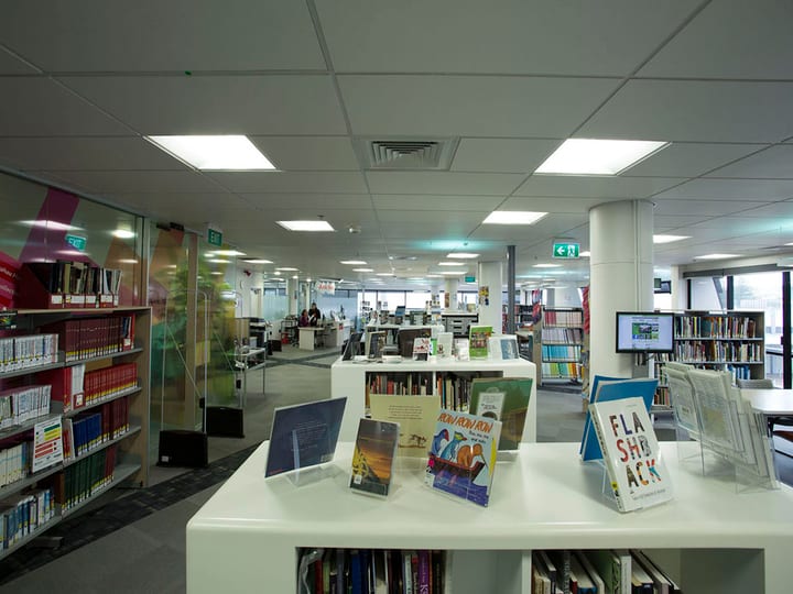 Library floor with book shelves, display stands, and featured titles on counter