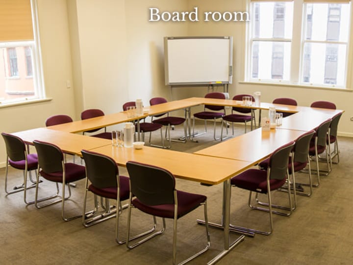 Meeting room with U-shaped table and chairs in boardroom layout