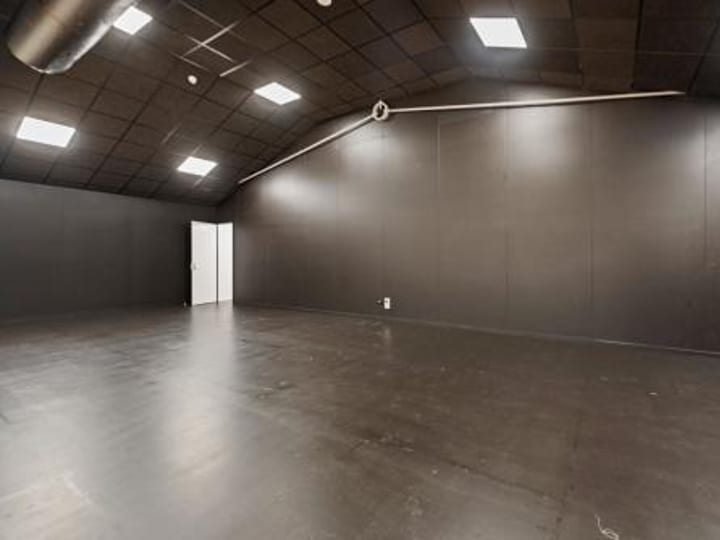 Dark-painted empty room with black ceiling and resin floor