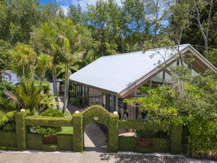 Timber and glass pavilion building surrounded by native plantings