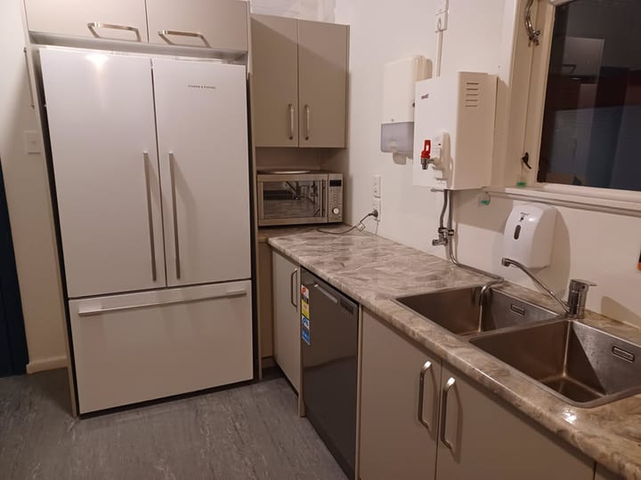 Kitchen with fridge, microwave, and double sink