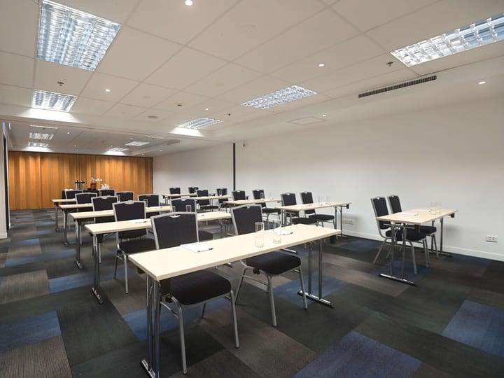 Meeting room with classroom table layout and stacked chairs