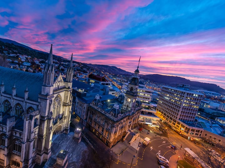 Aerial view of a Gothic cathedral and city centre at dusk with colourful sky