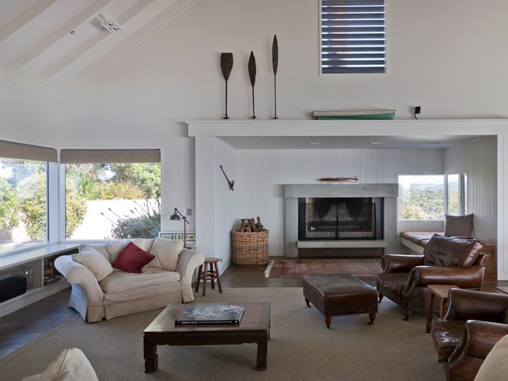 Vaulted lounge with fireplace, leather armchairs and bay views