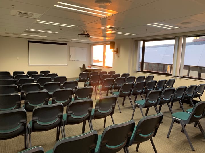 Conference room with rows of chairs and projection screen