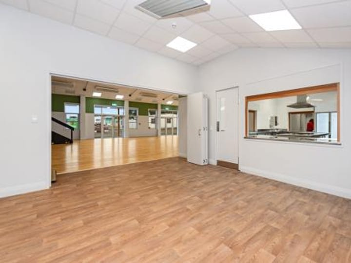 Plain empty room with timber floor and adjoining room view