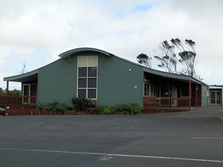 Green corrugated iron hall exterior with curved roof and verandah