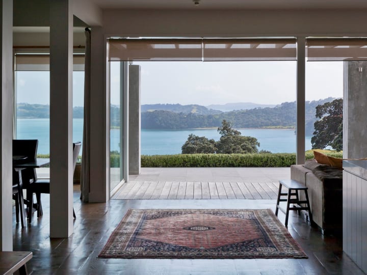 Open living and dining area with harbour views through full-width opening