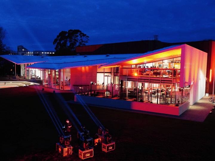 Contemporary building with red and orange cladding lit up at night