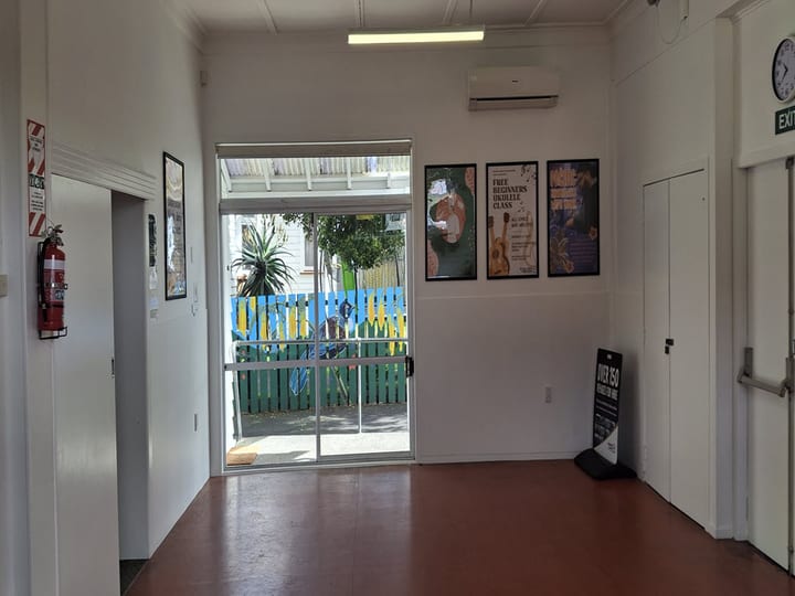 Hallway with sliding door to outdoor area and framed posters on white walls