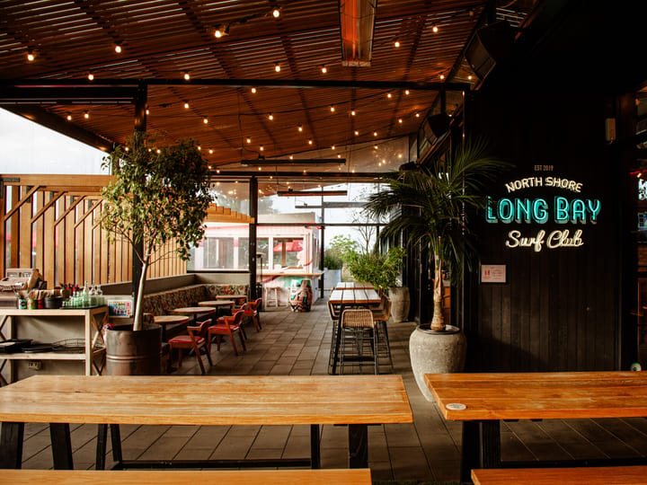 Covered outdoor terrace with neon signage and festoon lights