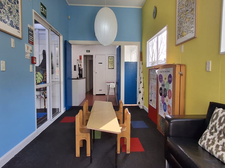 Blue and yellow painted room with small tables, chairs and paper lantern