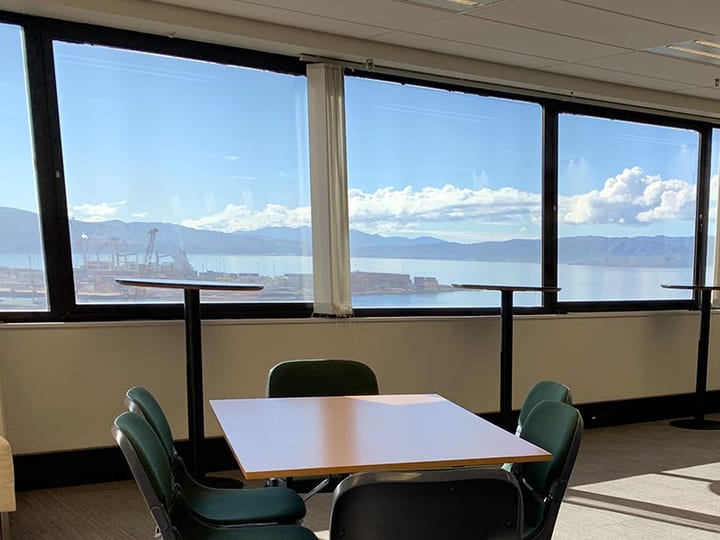 Meeting room with named glass door entry and sunset harbour view