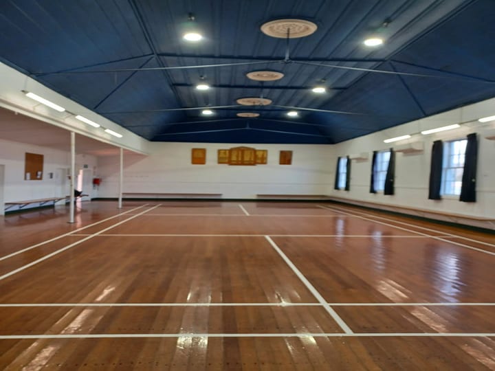 Hall interior from opposite end showing timber floor and blue arched ceiling