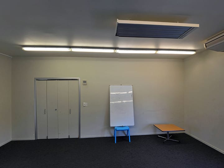 Small plain room with desk, chairs and brochure rack