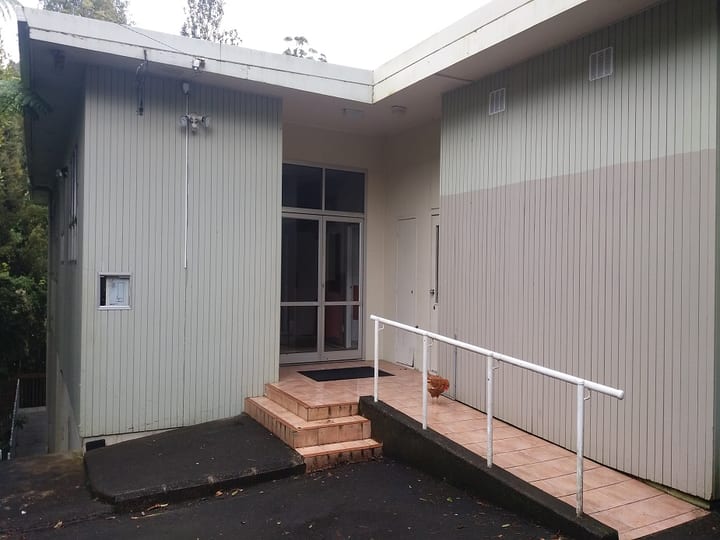 Close view of community hall entrance with ramp and vertical board cladding